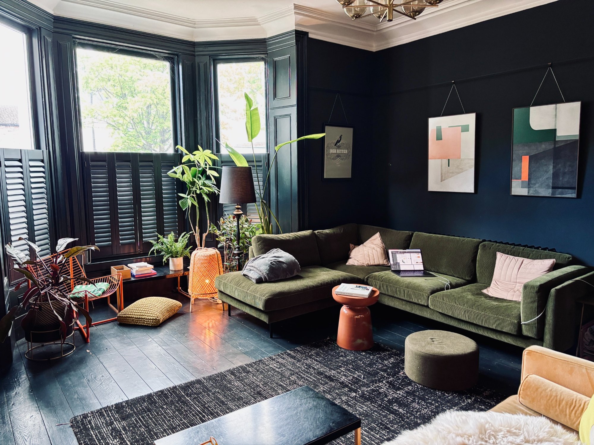 Sitting room with green sofa and dark painted walls